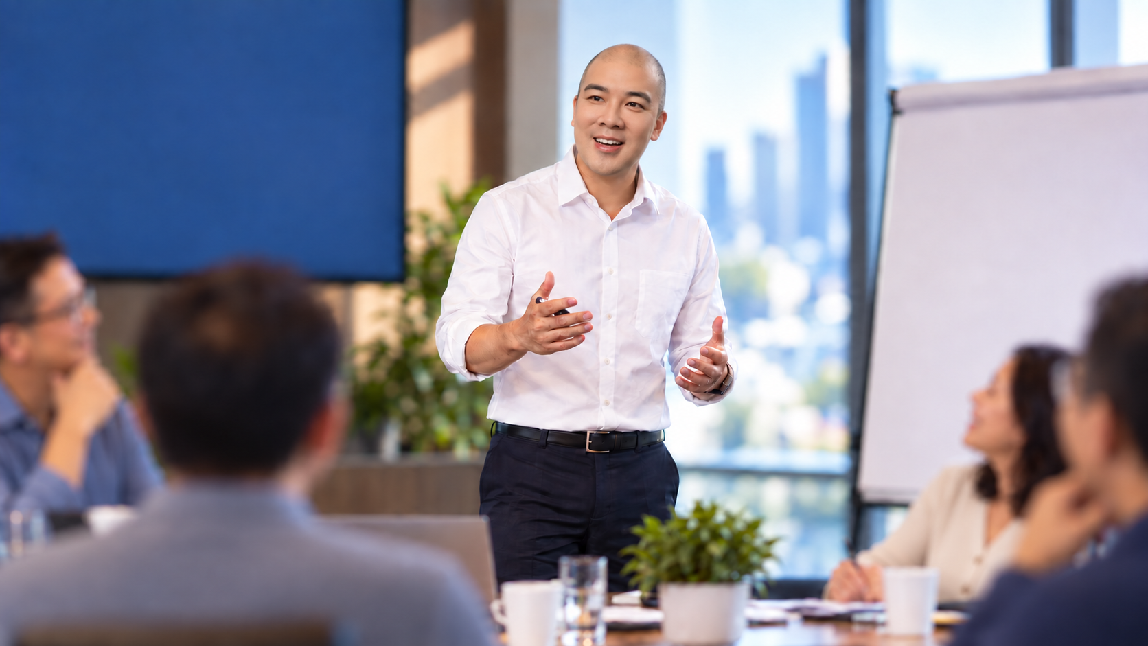 Norbert Woo speaking with a leadership group around a boardroom table